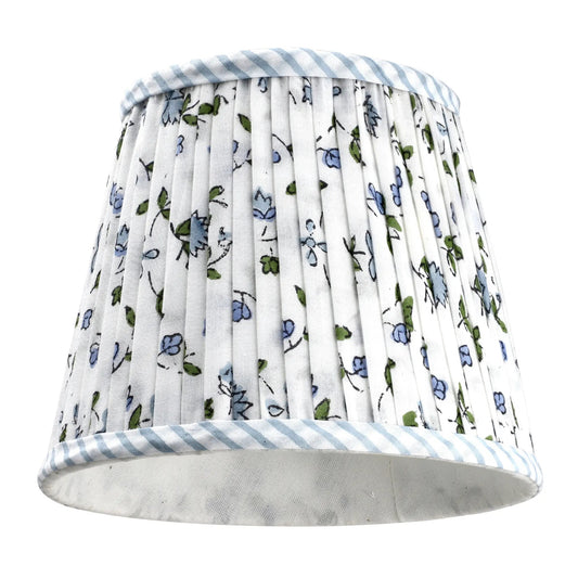 Floral patterned lampshade with striped trim on a white background