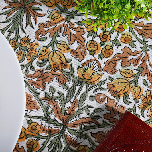Close-up of a floral patterned fabric with brown, green, and orange colors.