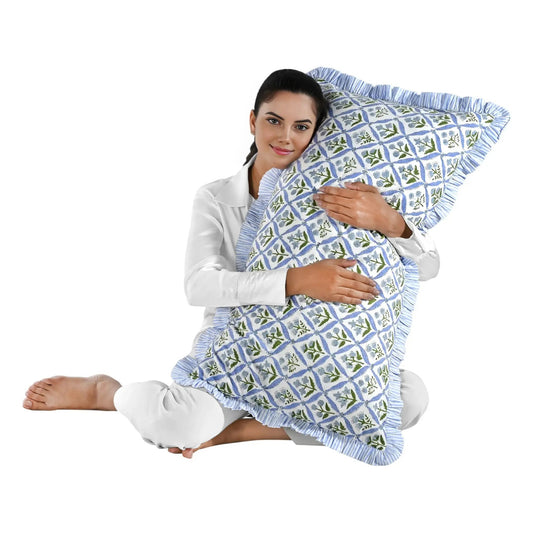 Woman holding a large blue floral block print cotton pillow with green edges.