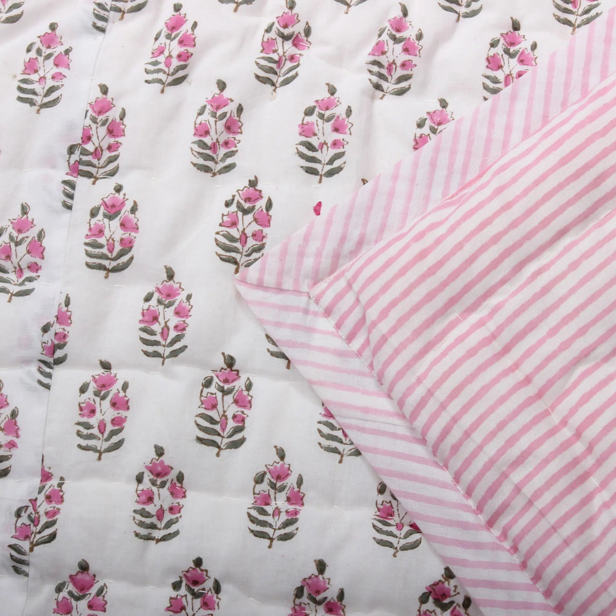 Floral patterned fabric with pink and white striped fabric on a white background