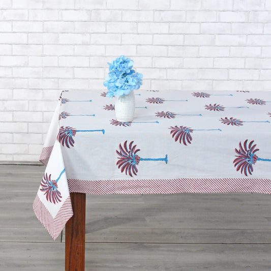Decorative tablecloth with red and white palm tree pattern on a plain background with striped border