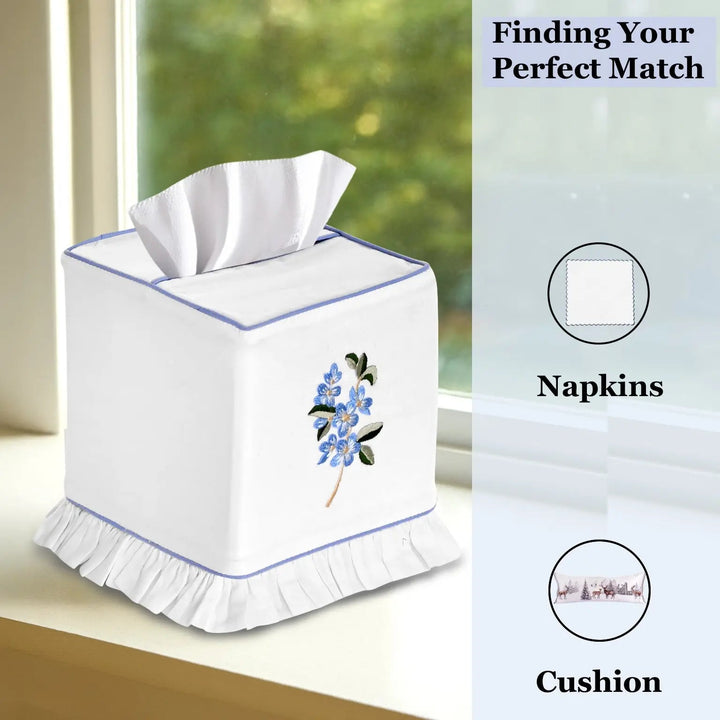 White tissue box cover with floral design on a windowsill, with text &