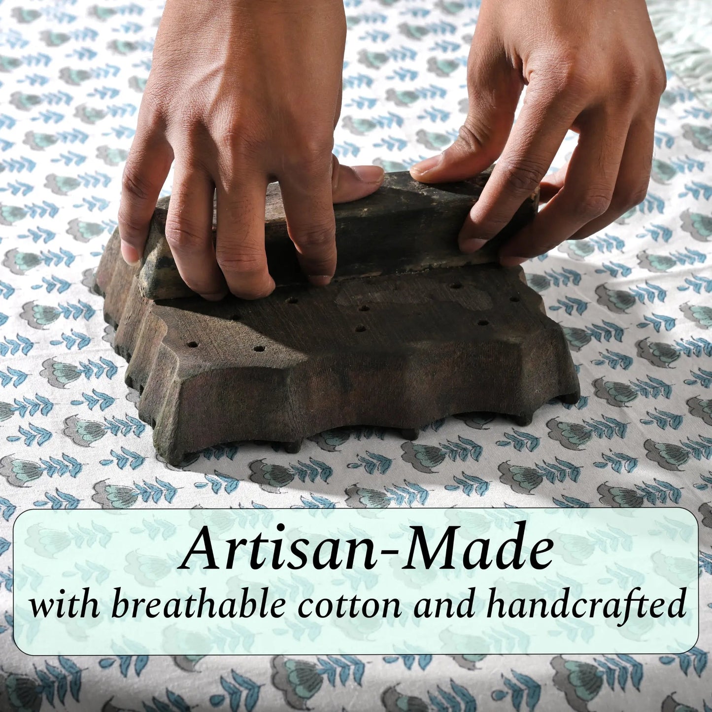 Artisan hand-block printing floral design on cotton fabric.