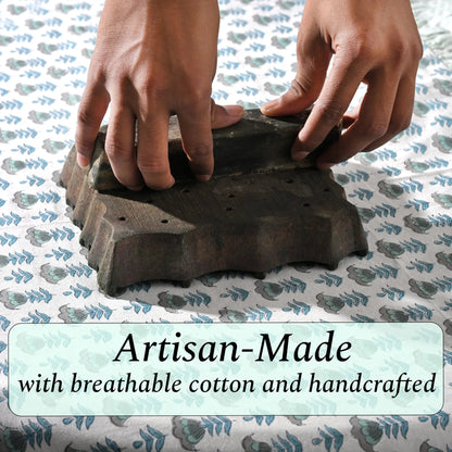 Artisan hand-block printing floral design on cotton fabric.