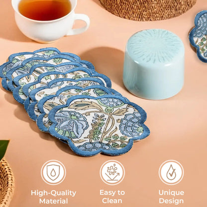 Set of floral coasters with a cup of tea and a container on a beige surface.