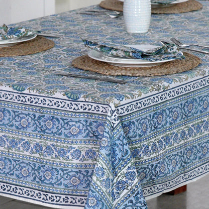Table setting with a blue patterned tablecloth on a wooden table.
