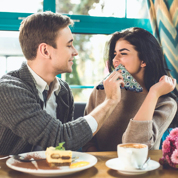 Man and woman sharing a dessert and coffee at a cafe