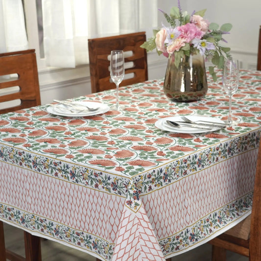 Tablecloth with floral pattern on a wooden table set for dinner