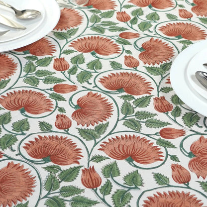 Floral patterned tablecloth with red flowers and green leaves on a white background