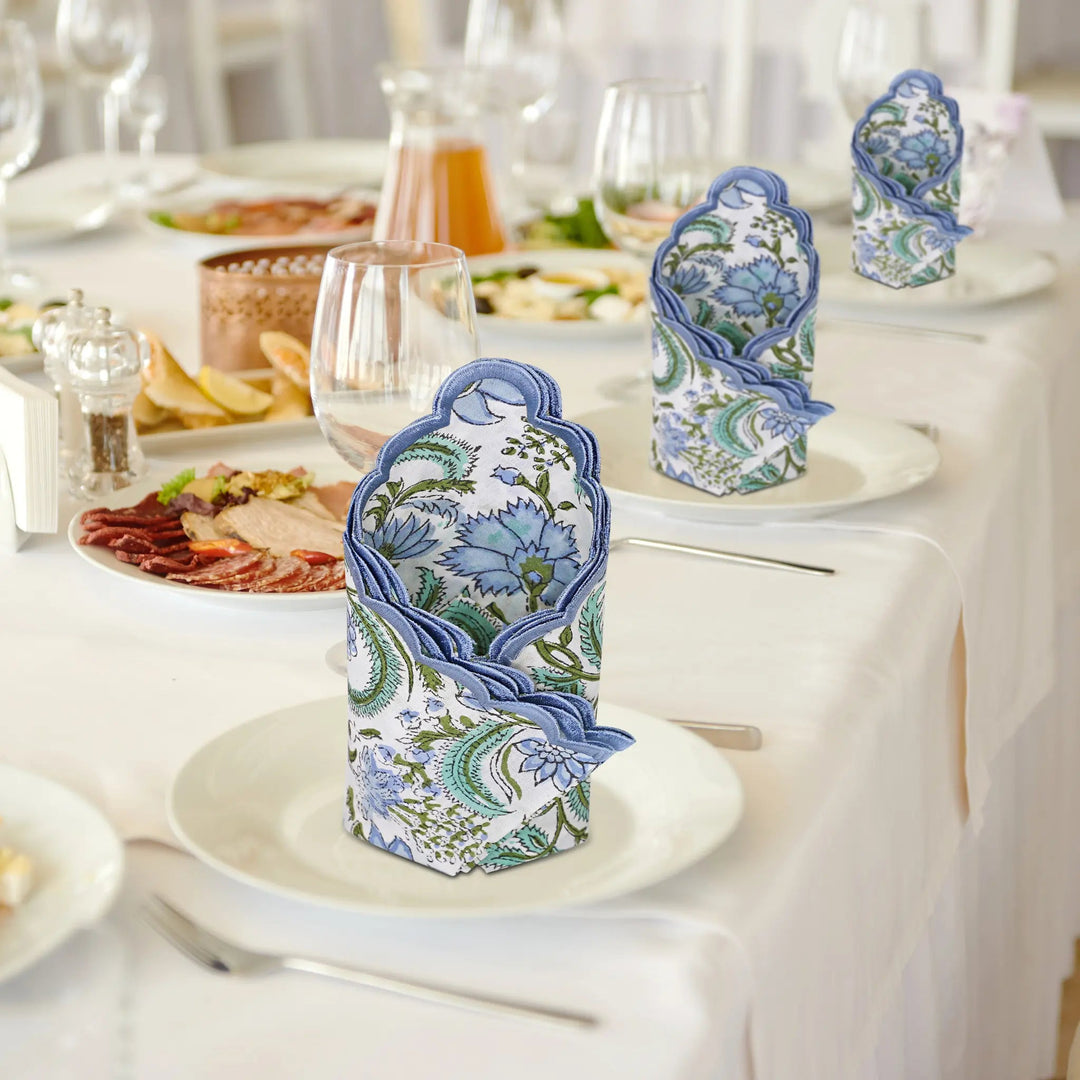 Decorative boxes with floral patterns on a table setting with plates and glasses.