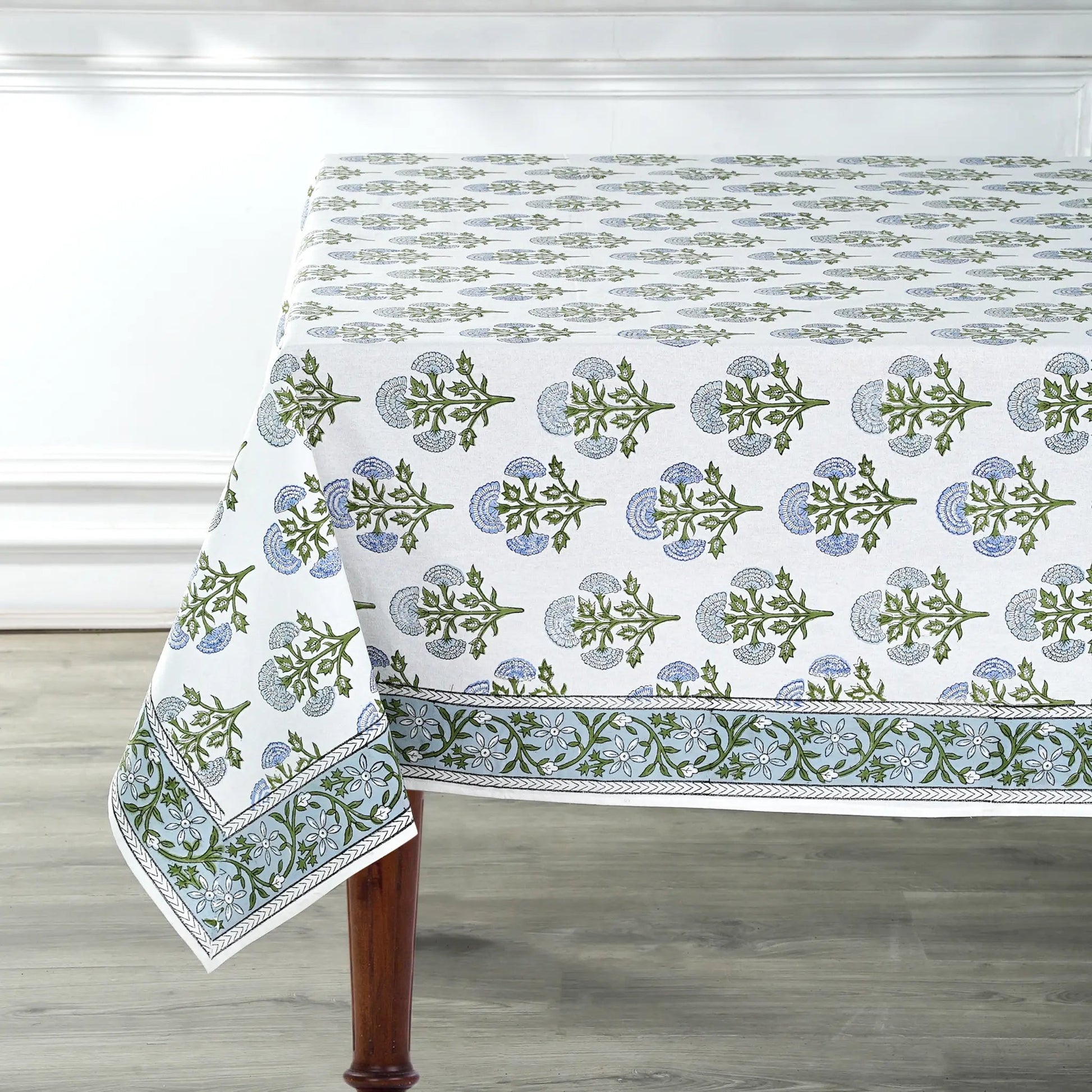 Tablecloth with green floral pattern on a wooden table