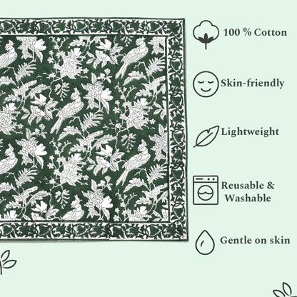Green fabric with white floral and bird pattern, featuring icons and text about fabric properties.