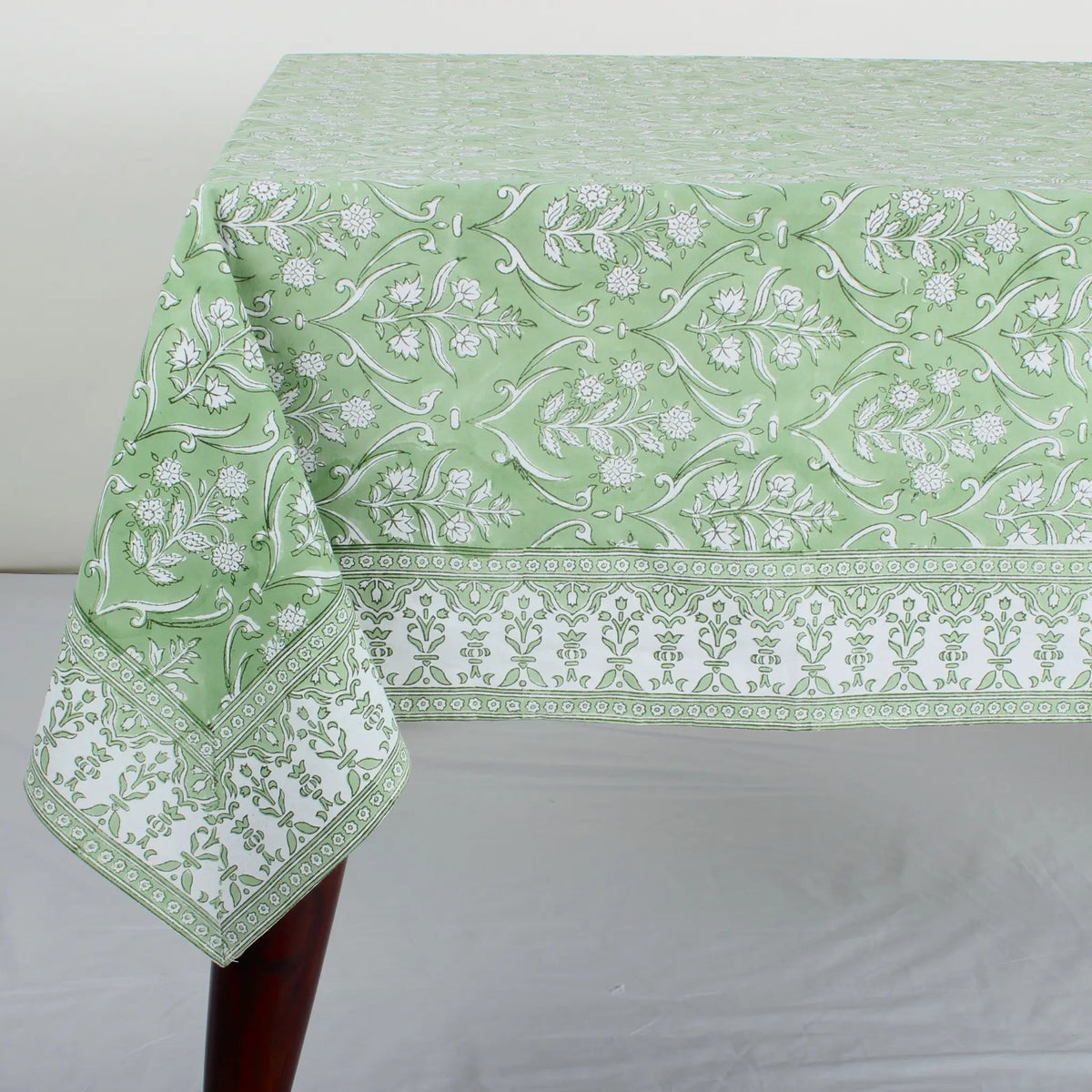 Green floral patterned tablecloth on a white surface
