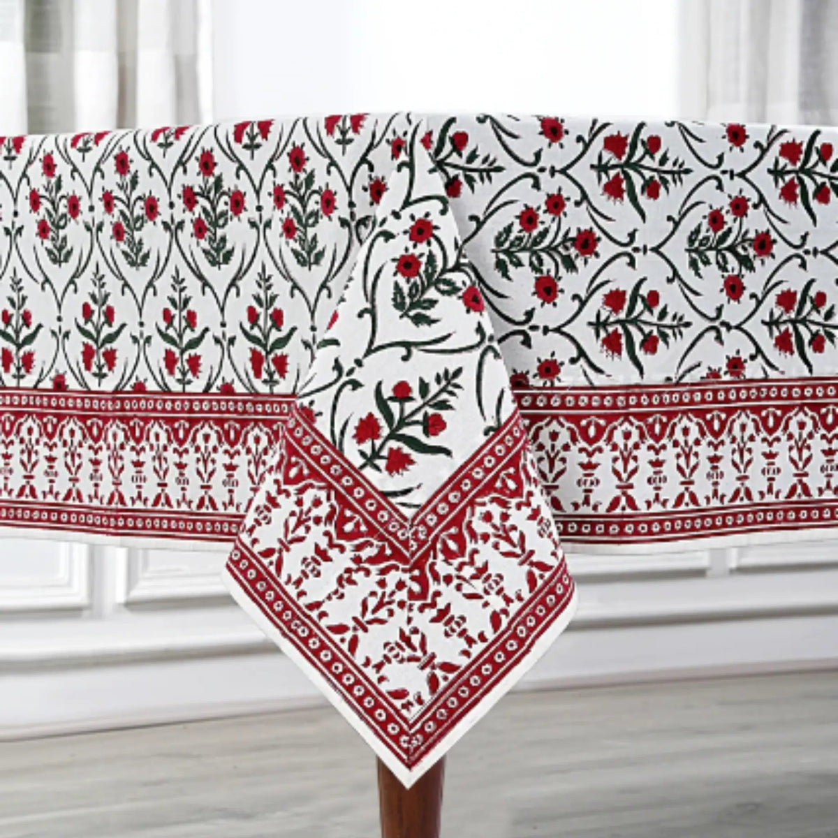 Decorative tablecloth with red and black floral patterns on a white background