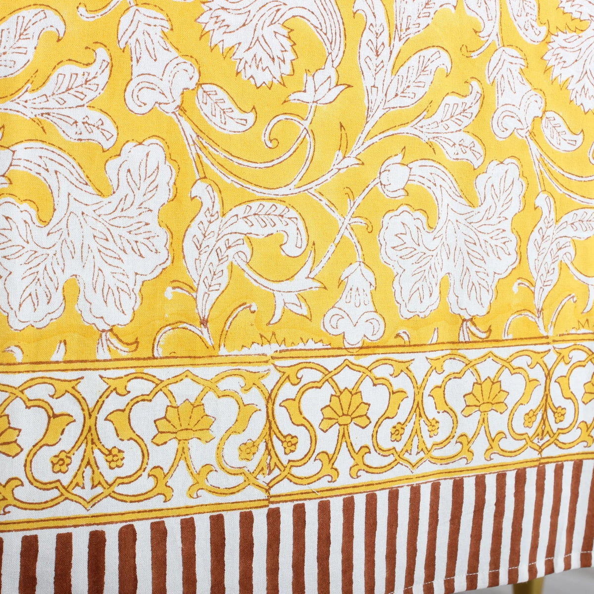 Close-up of a fabric with white floral patterns on a yellow background