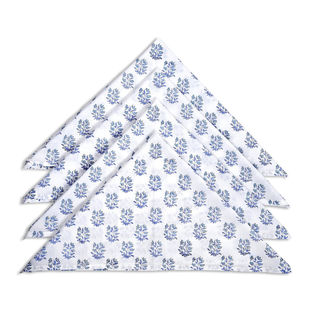 Set of four white napkins with blue floral pattern on a white background