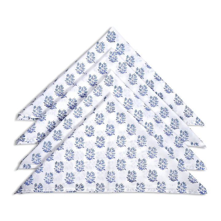 Set of four white napkins with blue floral pattern on a white background