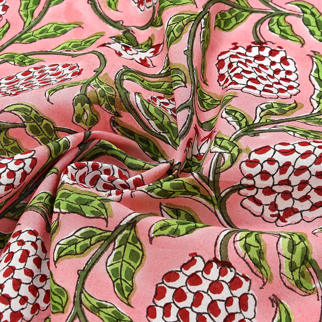 Floral patterned fabric with red and white flowers on a pink background