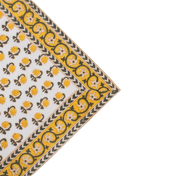 Corner of a fabric with yellow and black pattern on a white background