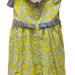 Yellow floral dress with black and white ruffled top on a hanger against a white background