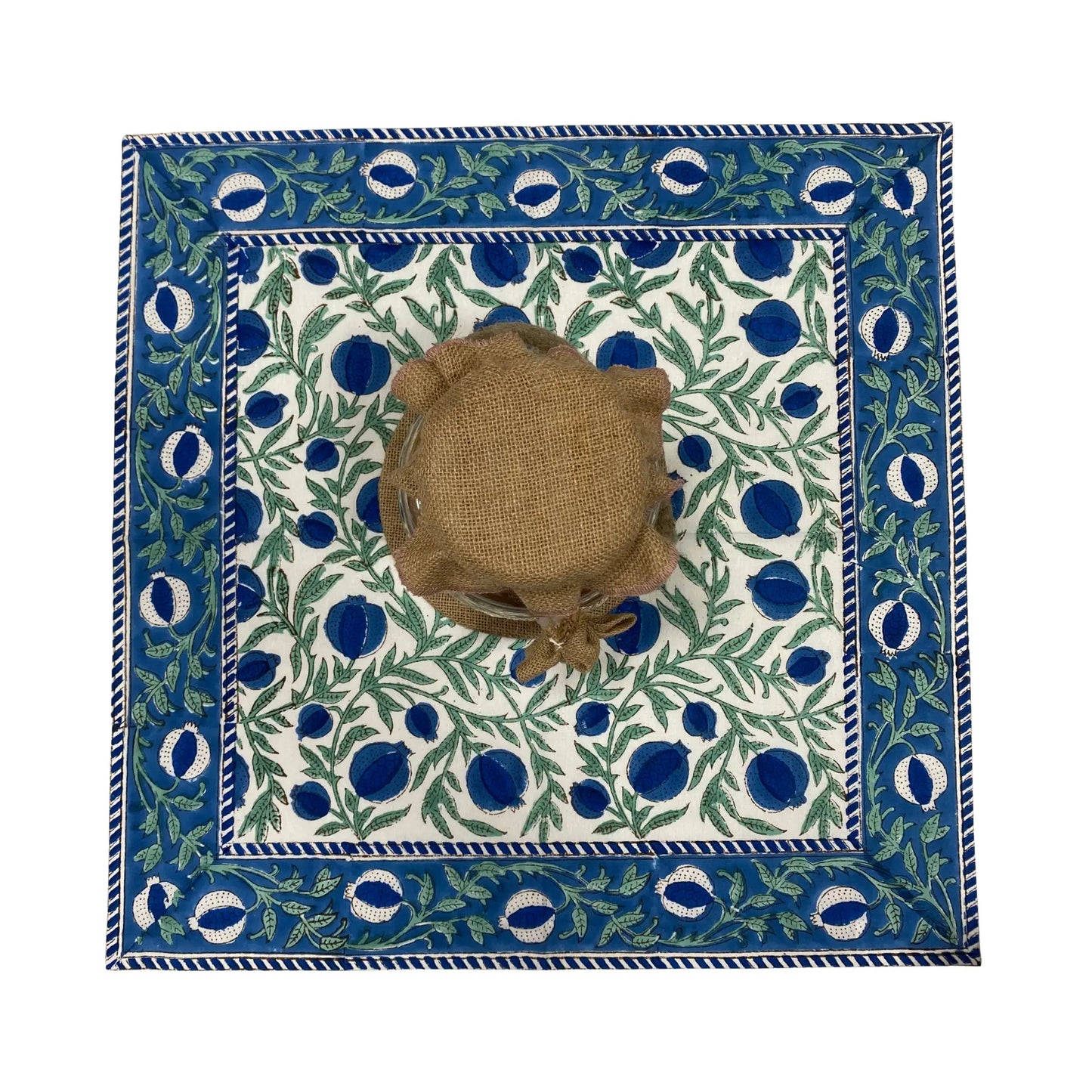 Decorative tablecloth with blue and green pattern on a white background