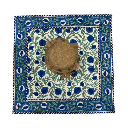 Decorative tablecloth with blue and green pattern on a white background