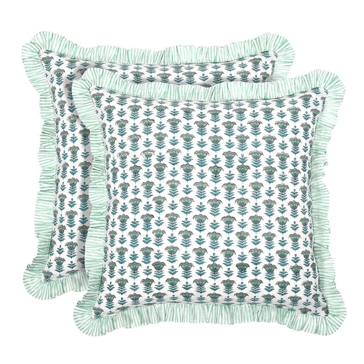 Two decorative pillows with floral patterns and fringes on a white background
