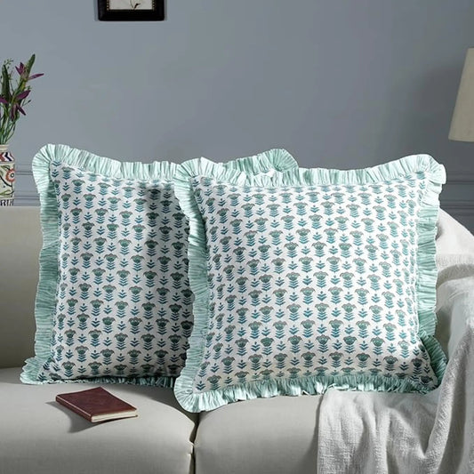 Two decorative pillows with green patterns on a gray sofa.