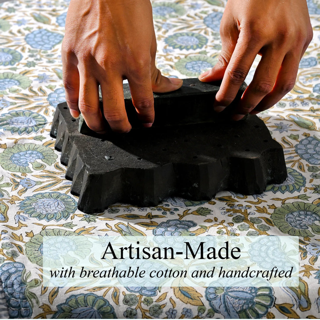 Black rubber mat with textured surface being held by hands on a floral-patterned fabric background, with &