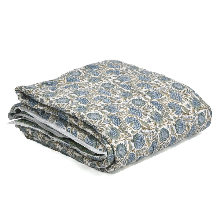 Folded floral-patterned quilt on a white background