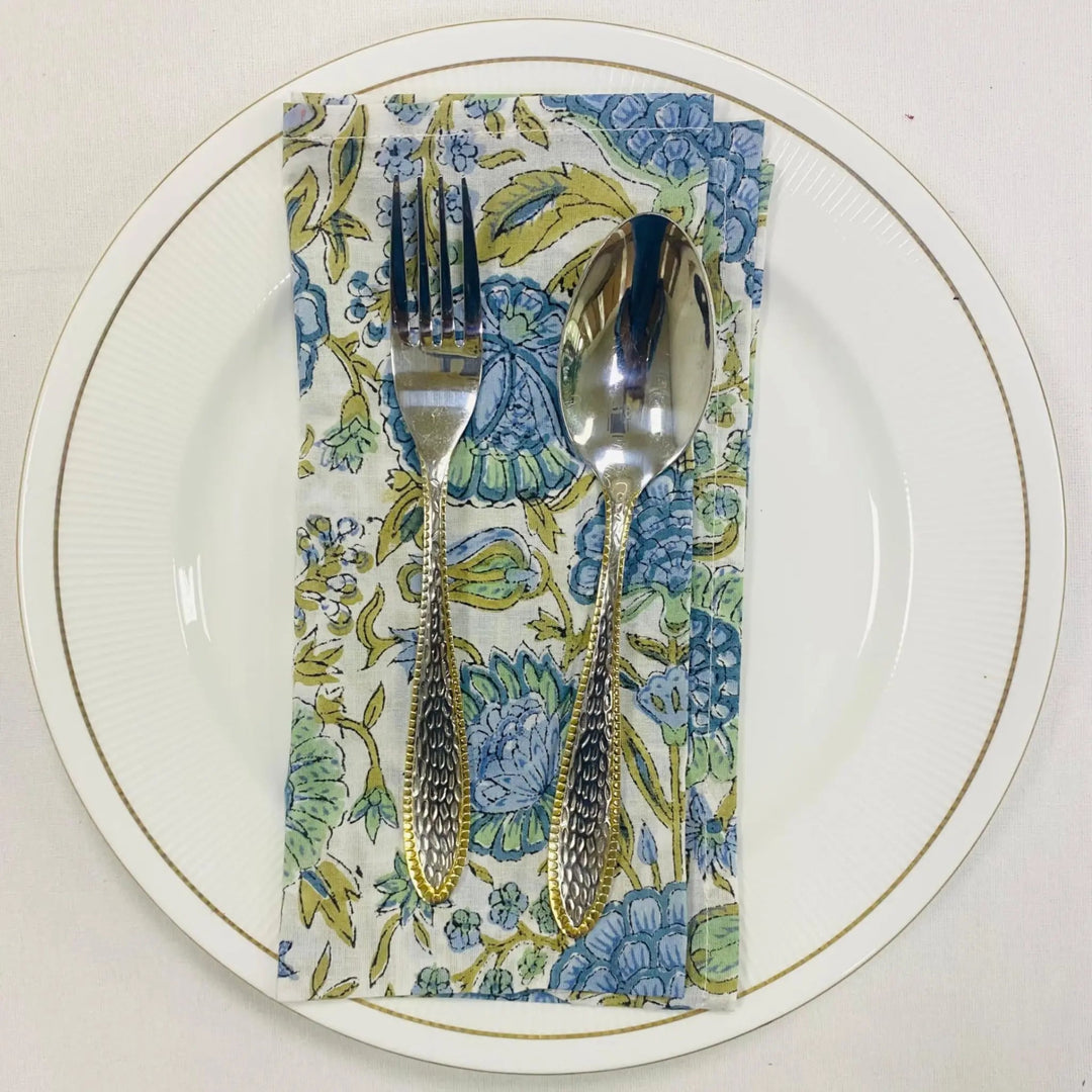 Silverware on a floral napkin with a white plate