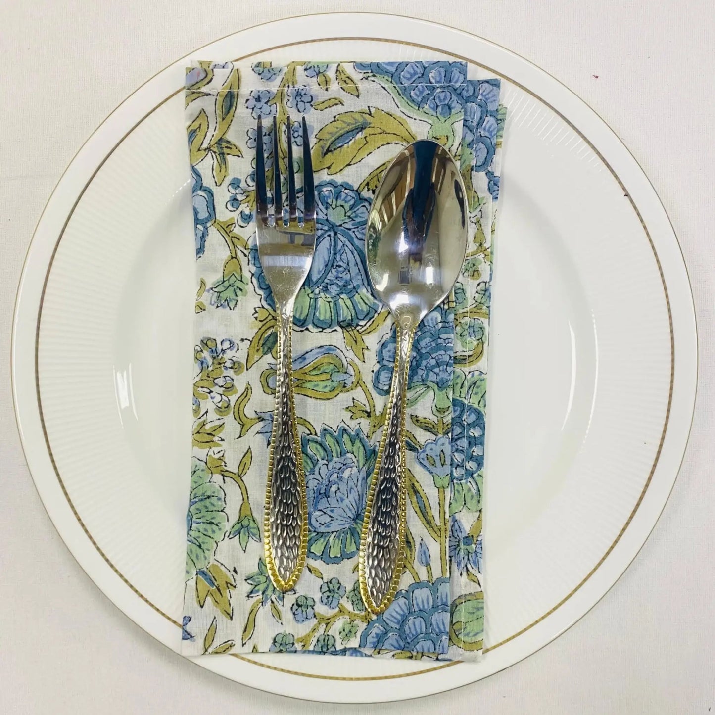 Silverware on a floral napkin with a white plate