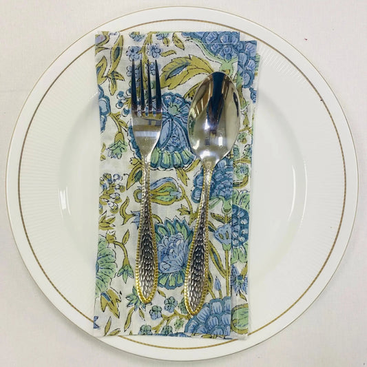 Silverware on a floral napkin with a white plate