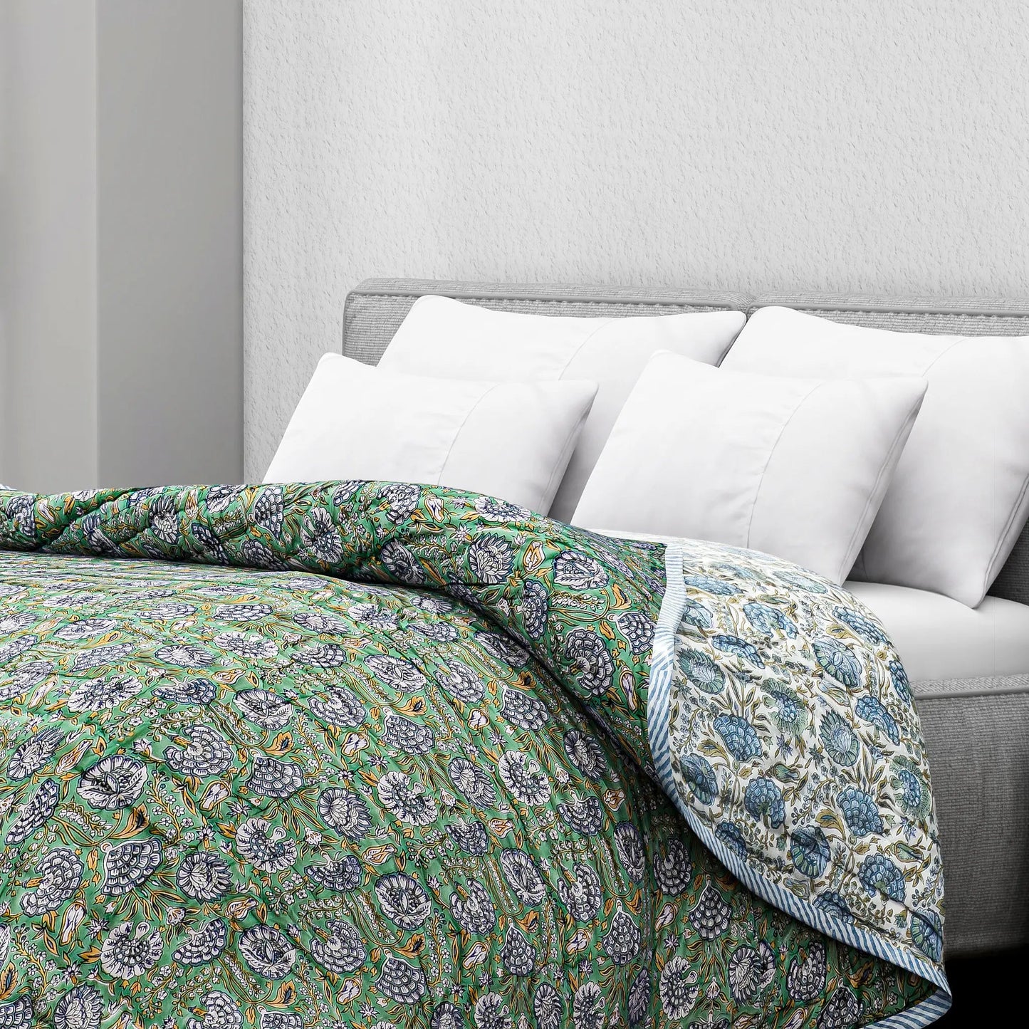 Floral patterned comforter on a bed with white pillows and a gray headboard.