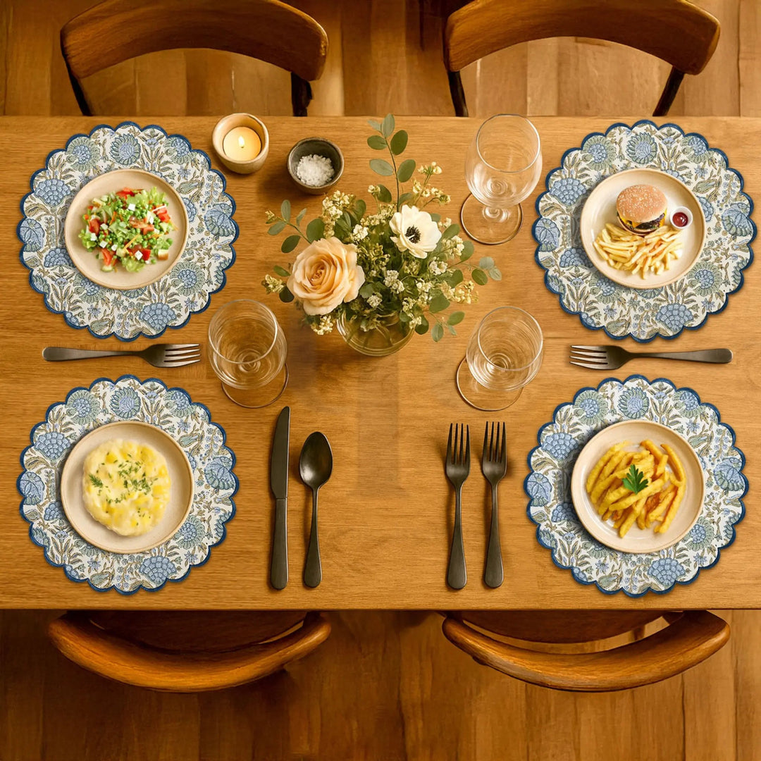 Dining table set with plates of food, glasses, and cutlery on a wooden table.