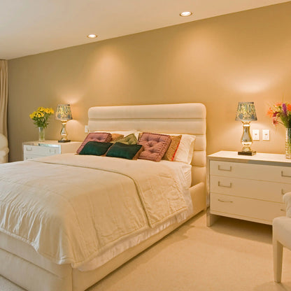 Neatly made bed with decorative pillows in a bedroom setting.