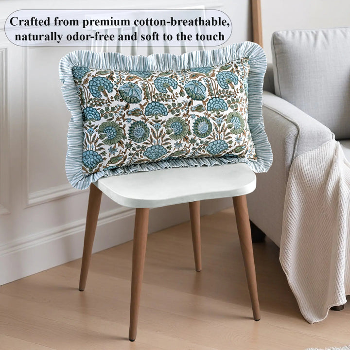 Decorative pillow with floral pattern on a chair in a room setting.
