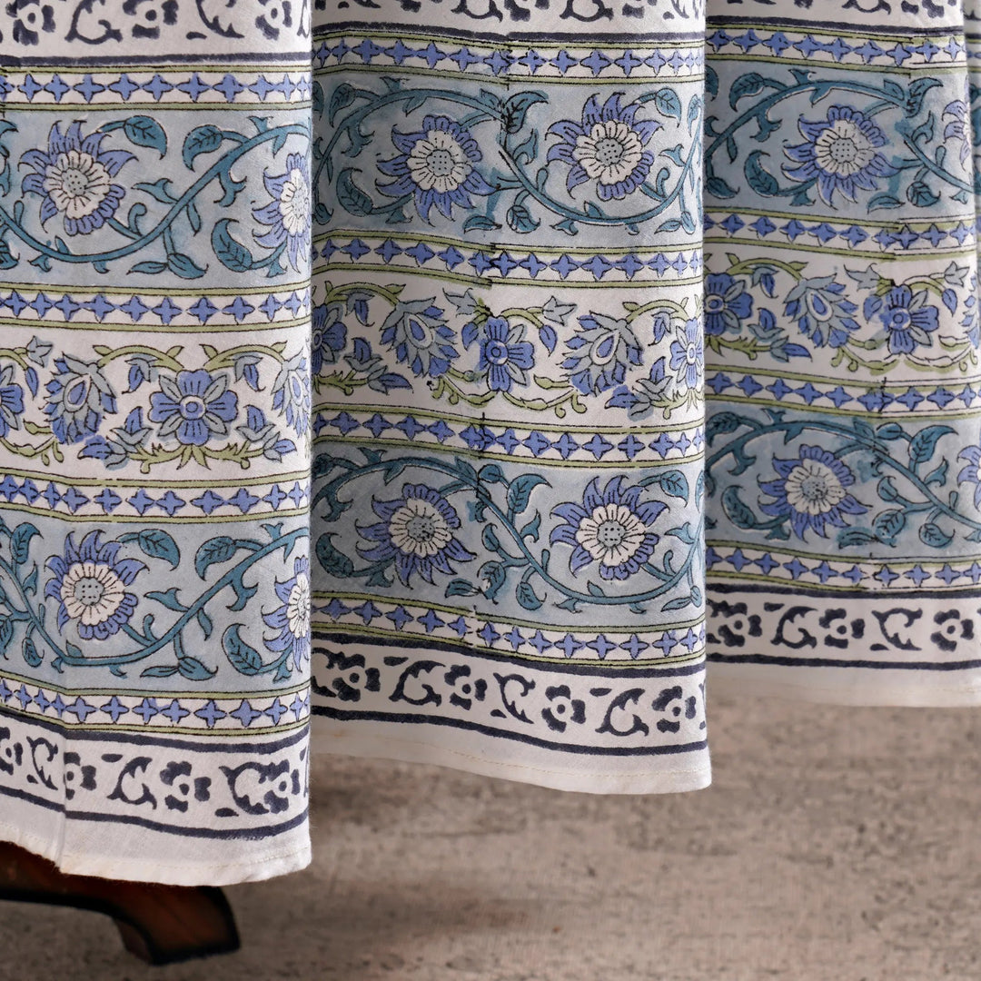 Close-up of floral patterned fabric with blue and green designs on a neutral background