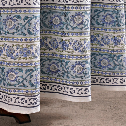 Close-up of floral patterned fabric with blue and green designs on a neutral background