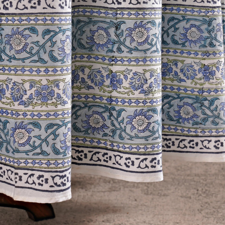 Close-up of floral patterned fabric with blue and green designs on a neutral background