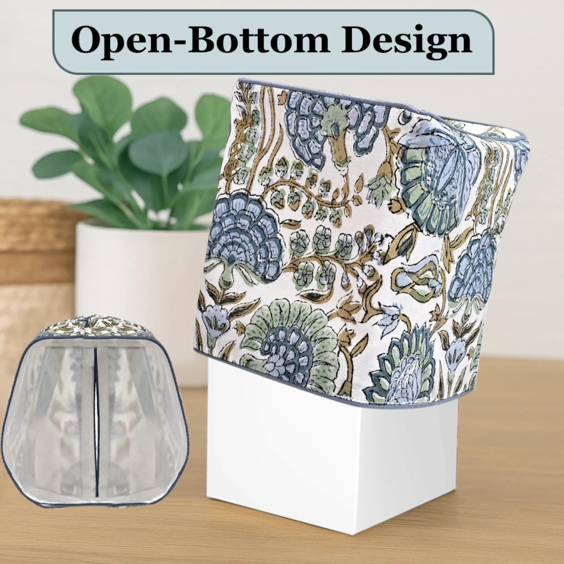 Floral-patterned product with open-bottom design on a wooden surface, plant in the background.