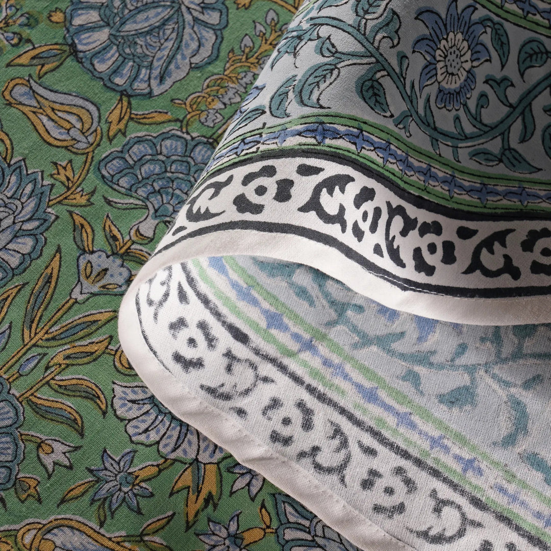 Close-up of a fabric with intricate patterns and text on a green background
