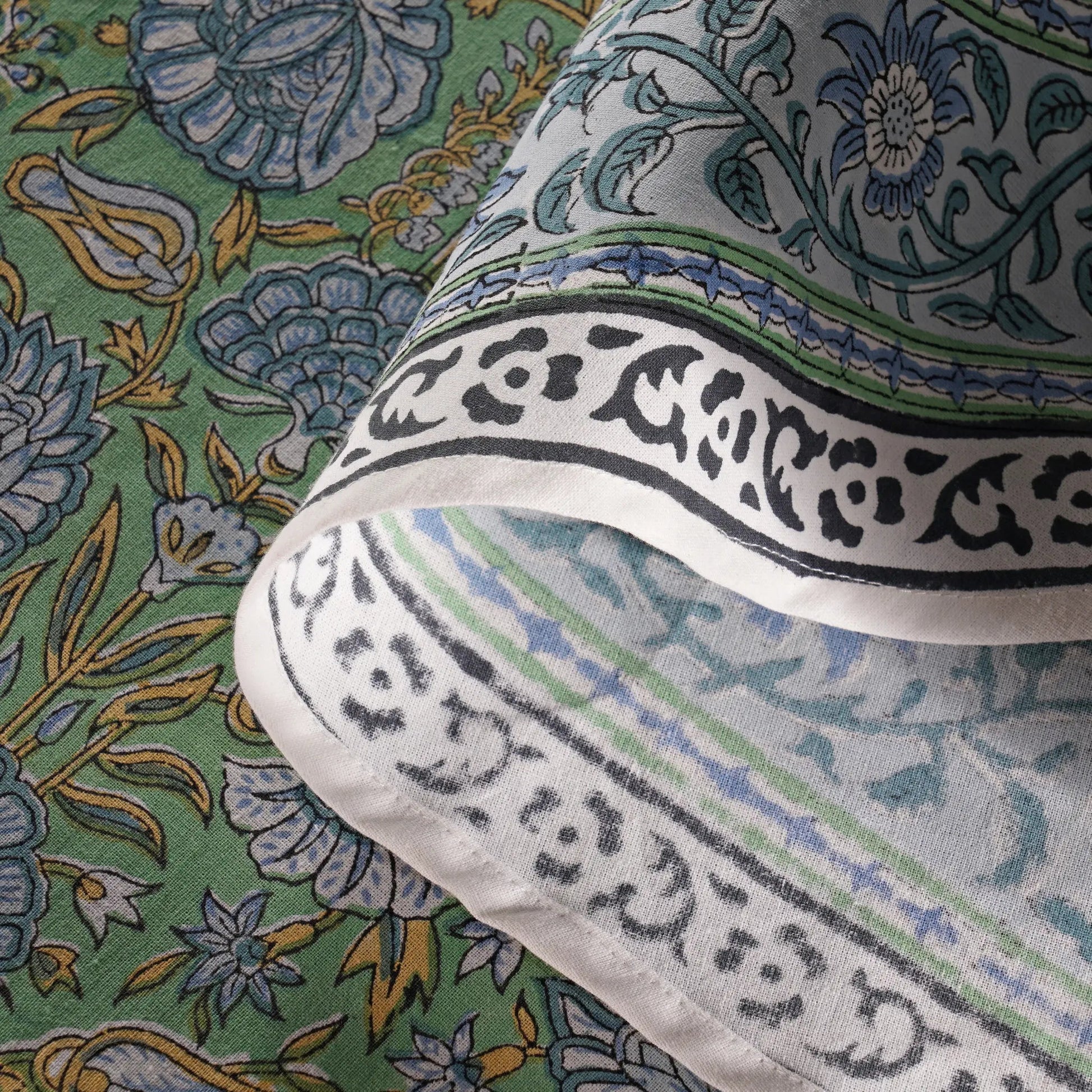 Close-up of a fabric with intricate patterns and text on a green background