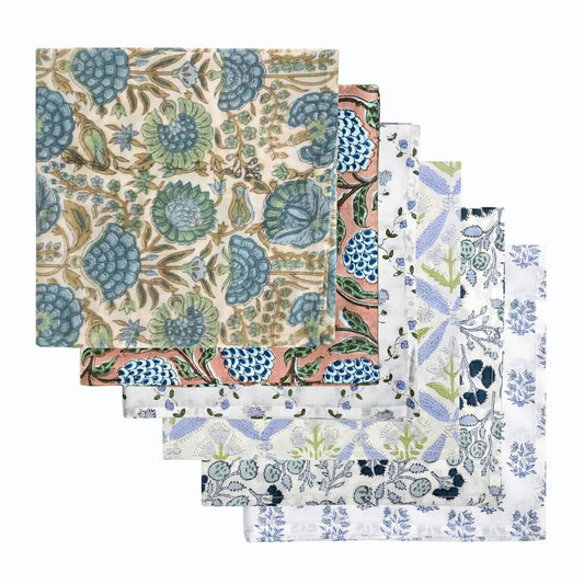 Set of four floral patterned napkins on a white background