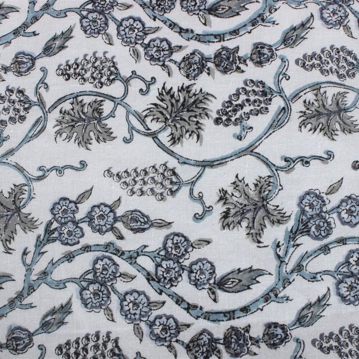 Patterned fabric with floral and vine designs in blue on a white background