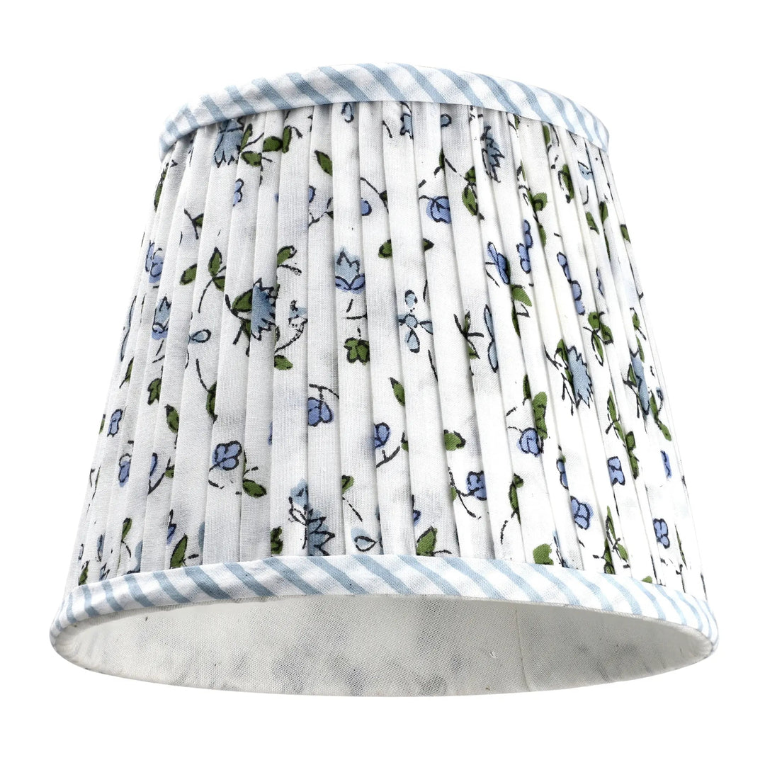 Floral patterned lampshade with striped trim on a white background
