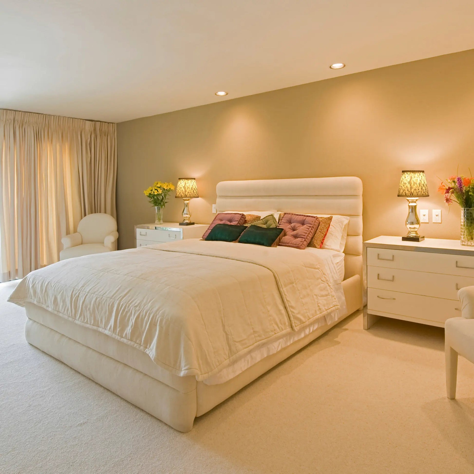 Neatly made bed in a bedroom with two nightstands and lamps.