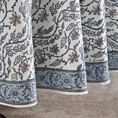 Close-up of patterned fabric with floral and vine designs on a neutral background