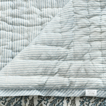 Quilted fabric with blue and white stripes on a floral background