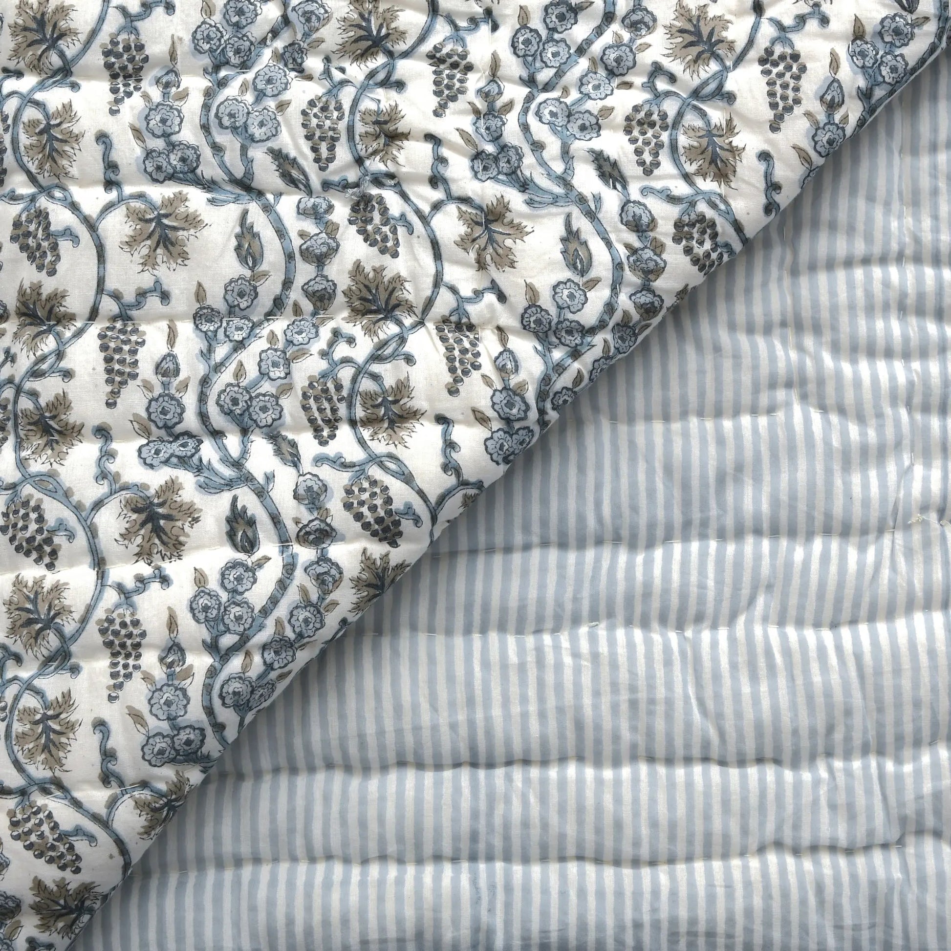 Close-up of floral-patterned fabric and striped fabric with visible texture